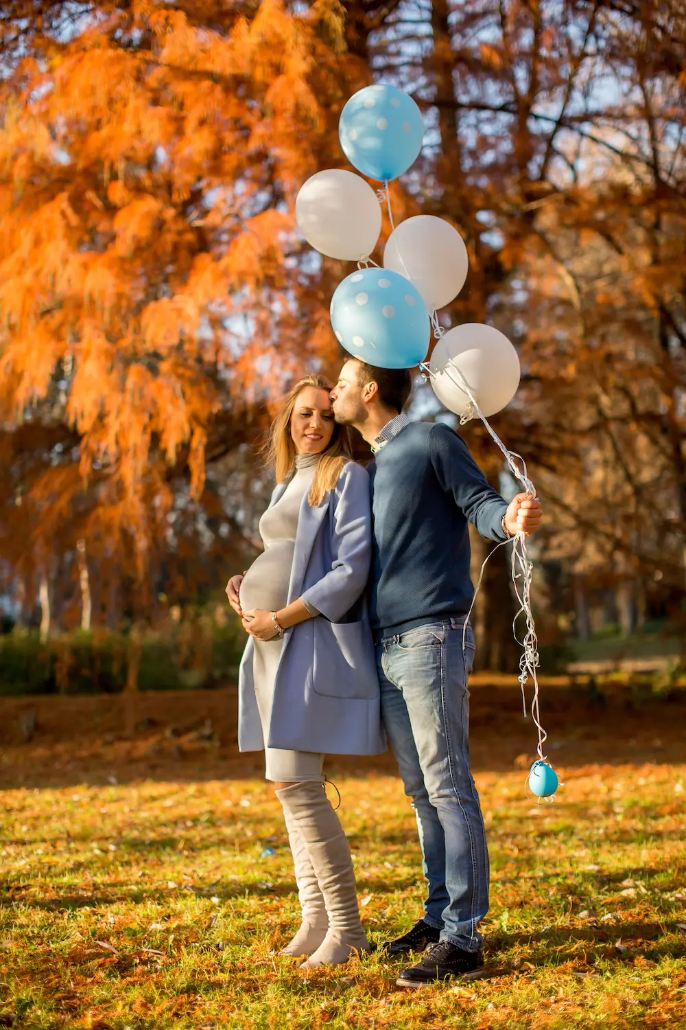Happy couple with balloons at gender reveal party.